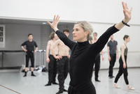 Choreographer Crystal Pite leading the dancers in rehearsal in a ballet studio