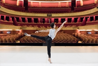 A photo of Principal Dancer Guillaume Cote on stage in Paris with a view to the empty auditorium